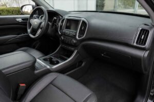Czarne wnętrze Chevroleta z kierownicą, ekranem dotykowym i konsolą środkową z uchwytami na kubki